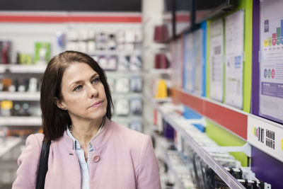 Female customer viewing technology in electronics store