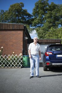 Senior man in front of car