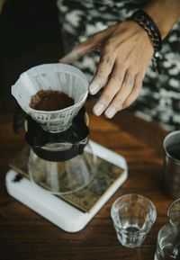 Cropped hand of person making coffee at home