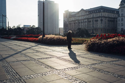 Man standing on street against buildings in city