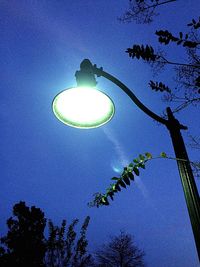 Low angle view of illuminated street light against blue sky