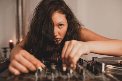 Close-up of fashionable young woman playing music at home