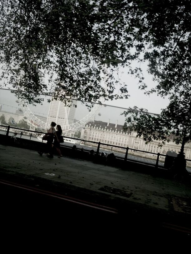 railing, men, lifestyles, bridge - man made structure, leisure activity, silhouette, full length, tree, water, walking, connection, river, rear view, sky, person, standing, bridge