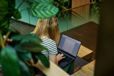 Woman using laptop in coworking. female freelancer typing on laptop keyboard. online work in cafe