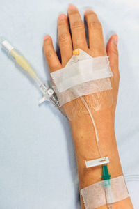 Close-up of woman hand with medical equipment on bed