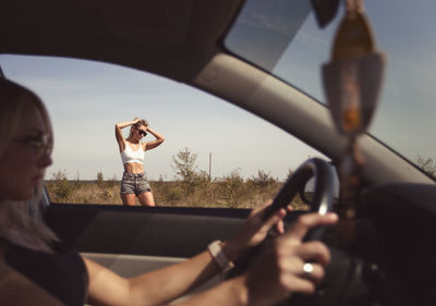 Low angle view of young woman holding car