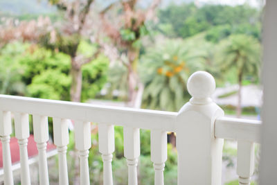 Close-up of white fence by railing