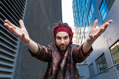 Portrait of man gesturing while standing in city