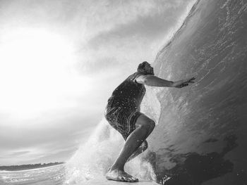 Full length of man surfing in sea against sky