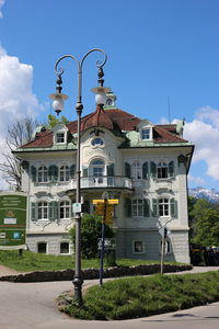 Low angle view of street light by building against sky