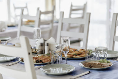 Beautifully laid tables with glasses and appliances at morning in restaurant. empty glasses