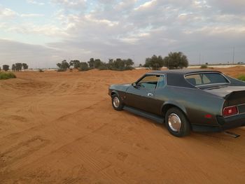 Car on road by land against sky