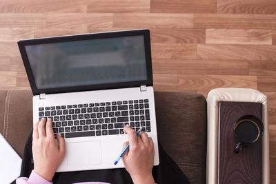 Cropped image of woman using laptop