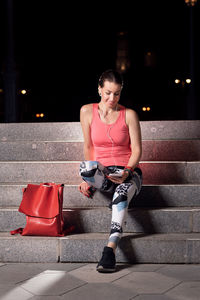 Woman sitting on staircase at night