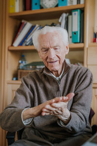 Senior man using hand sanitizer at home