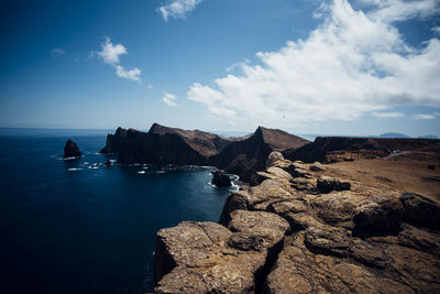 Scenic view of rocks in sea against sky