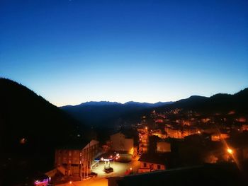 Illuminated cityscape against clear sky