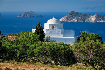 View of milos island and greek orthodox traditional whitewashed church in greece