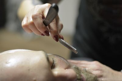 Midsection of barber shaving man at salon