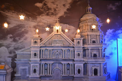 Low angle view of illuminated building against sky at night