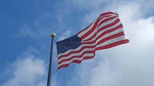 Low angle view of american flag against blue sky