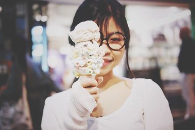 Portrait of mature woman holding ice cream cone while standing outdoors