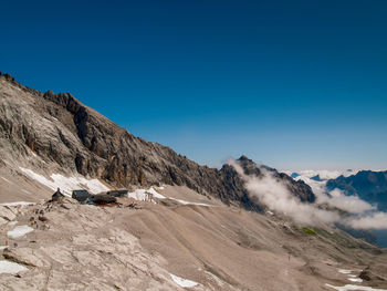 Scenic view of snowcapped mountains against clear blue sky