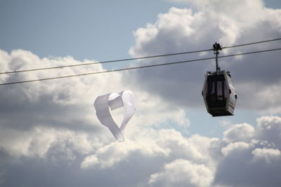 Low angle view of overhead cable car against sky