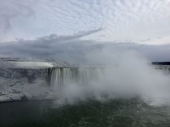 Scenic view of waterfall against sky