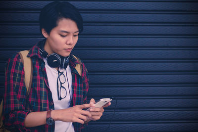 Teenage girl using mobile phone while standing outdoors