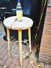 High angle view of empty chairs and table on sidewalk by building