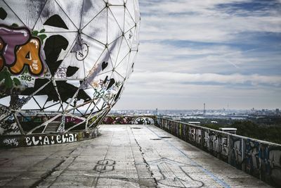 Graffiti on dome at communications tower against sky