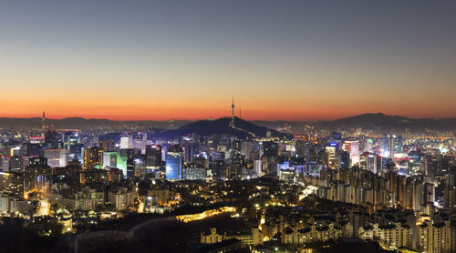 High angle view of illuminated buildings against sky at sunset