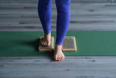 Low section of woman standing on wooden floor