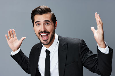 Portrait of businessman gesturing against white background