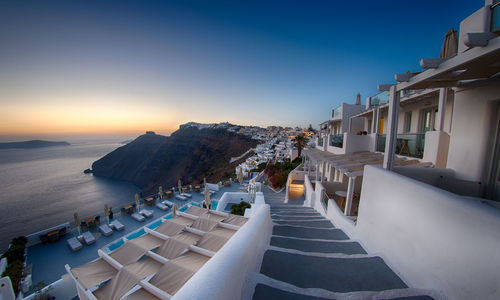 Empty chairs and tables against clear blue sky