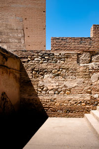 Stone wall of old building against sky