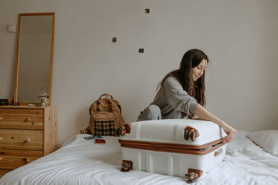 Woman with the baggage at home, preparing to flight