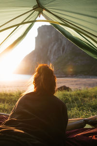 Rear view of woman looking through window
