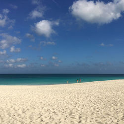 Scenic view of beach against blue sky