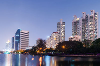 City skyline against clear blue sky at night