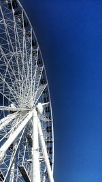 Low angle view of ferris wheel against clear blue sky