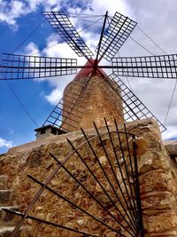 Low angle view of traditional windmill against sky