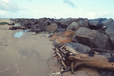 Rocks on beach against sky