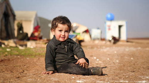 Portrait of boy sitting on field