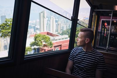 Young man looking through train window