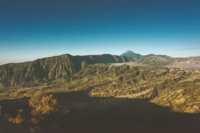 Scenic view of mountains against clear blue sky