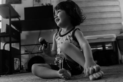 Young boy looking away while sitting on floor at home