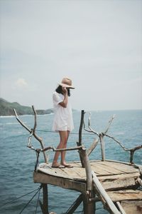 Woman standing by sea against clear sky