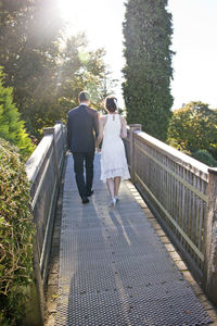 Rear view of women walking on bridge